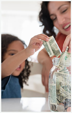 woman and child adding money to a jar
