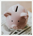 piggy bank atop money bills